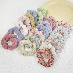 Set of floral and solid color chiffon scrunchies on a minimalist white background
