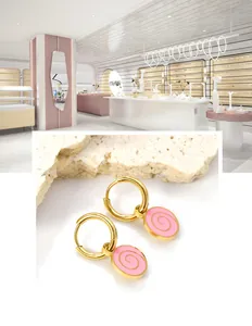 Detailed close-up of 18K gold stainless steel hoop earrings with pink spiral charm