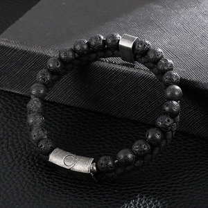 Macro shot of men's leather cord bracelet with volcanic stones and alloy buckle detail