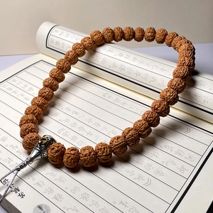 Macro shot of natural Rudraksha beads with metal charms on a vintage book