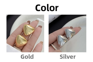 Close-up of minimalist geometric triangle earrings in polished gold and silver finishes