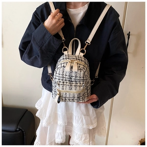 Detail of tweed mini backpack with gold hardware and ivory straps worn by model