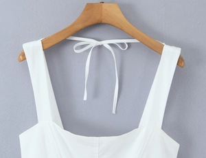Detailed back view of white square neck dress featuring a tied bow and wide straps