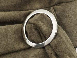 Detailaufnahme von olivgrünem Wildlederimitat mit einem dekorativen silbernen Metallring