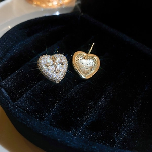 Luxurious gold heart earrings with zircon inlay and cross relief in a jewelry box