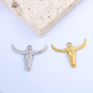 Detailed close-up of embossed bull head pendants in polished gold and silver finishes