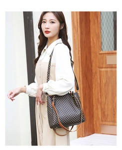 Retro shoulder bag with geometric print and brown leather trim on a model outdoors