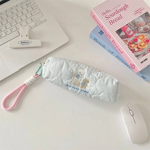 Close-up of quilted light blue pencil case with sheep embroidery and woven pink handle