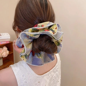 Close-up of oversized floral chiffon scrunchie with oil painting pattern and delicate edging