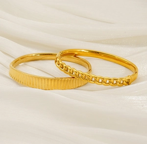 Detailed shot of gold-plated bangles with vertical stripes and twisted chain designs