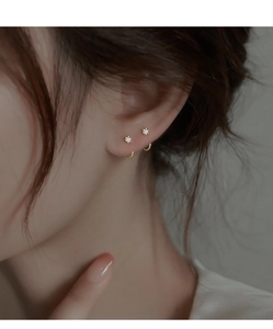Close-up of minimalist gold U-shaped earrings with zircon stones on female model