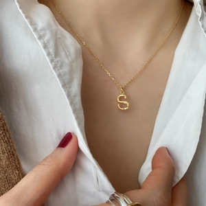 Minimalist 925 silver golden S letter pendant necklace worn on a cozy white shirt