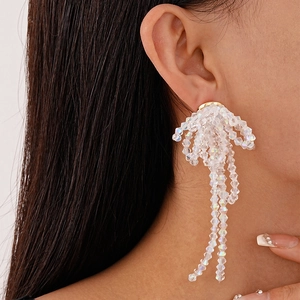 Detail of long tassel bow earrings with crystal beads and iridescent white droplets