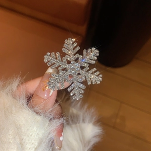 Macro detail of sparkling snowflake hair clip with silver crystals and starburst lighting