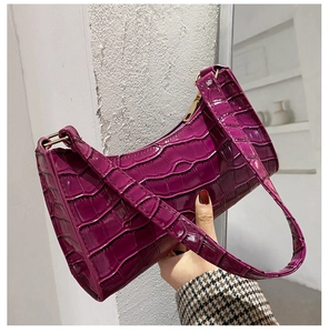 Close-up of purple crocodile pattern faux leather texture and gold metal zipper detail