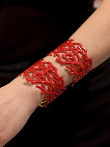 Détail d'un bracelet manchette rouge en forme de corail en acier inoxydable sur un modèle