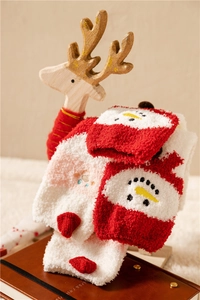 Close-up of red and white coral fleece Christmas socks with snowman jacquard pattern