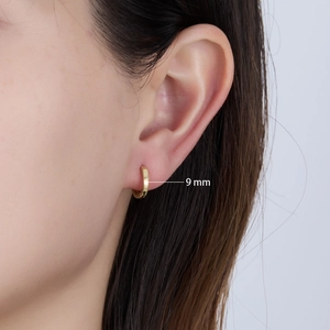 Model wearing 9mm gold minimalist round hoop earring showing size and texture