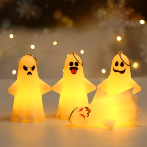 Macro detail of four glowing ghost mini lights with warm yellow LED for Halloween decor