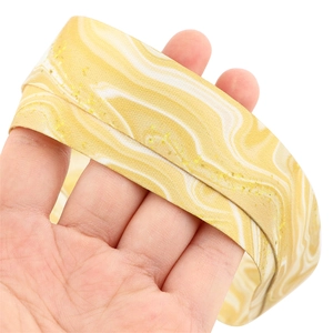 Close-up of yellow and white marble pattern fabric lanyard with gold glitter texture details