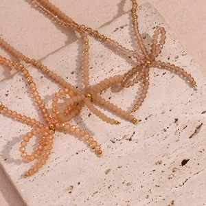 Detailed macro view of handmade champagne crystal beads and woven bow on the necklace