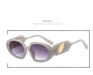 Detailed side view of purple oval sunglasses with a decorative golden leaf temple