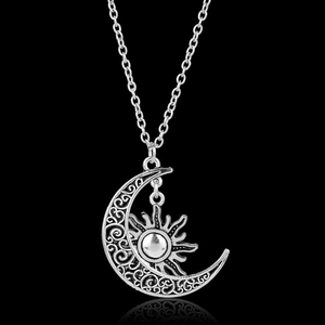 Vintage silver sun and moon pendant necklace with hollow pattern on black background