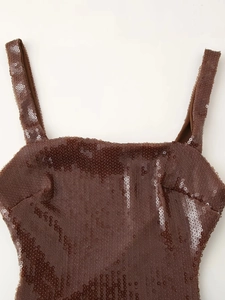 Detailopname van donkerbruine pailletten en fijne stiksels op een feestjurk