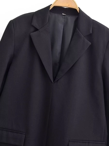 Detail of black blazer dress lapel and shoulder fabric texture in workplace style