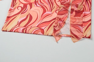 Detail of summer mini dress showing abstract swirl print and mesh ruffle hemline