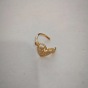 Detailed close-up of a gold heart ear cuff with sparkling zircon stone inlay