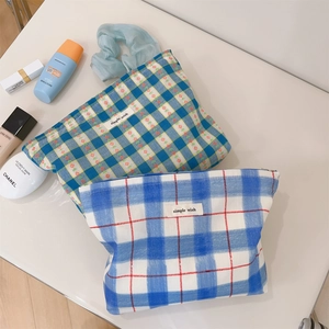Detail of floral plaid and blue checkered fabric cosmetic bags with zip and label