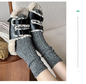 Detail of black leather winter slippers with white plush lining and metal buckles