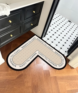L-shaped beige bathroom mat with dots and black border on a modern wooden floor