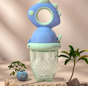 Detail of dinosaur baby fruit feeder with silicone mesh bag on a natural stone base