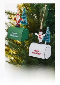 Detail of vintage metal mailbox ornament with Santa and mini tree on Christmas branch