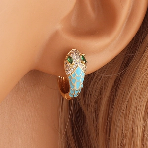 Gold snake hoop earring with blue enamel scales and green zircon eyes on model