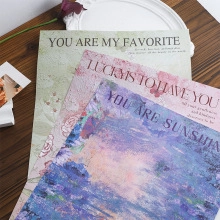 Three floral card inserts with romantic English quotes on a dark wood background