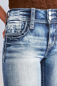 Close-up of high-waist pocket and stitching details on blue washed denim jeans