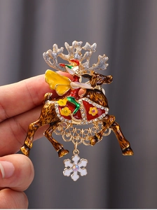 Detailed close-up of a Christmas reindeer brooch with colorful enamel and snowflake charm
