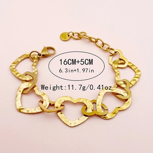 Detail of gold heart chain bracelet featuring hammer texture finish and engraved s.steel logo