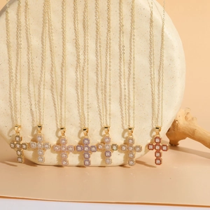 Detail of luxury cross pendants featuring 14K gold plating and colorful gemstones