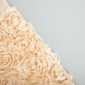 Detail of 3D cream rosette petals and delicate mesh fabric on the formal evening skirt