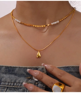 Vue détaillée d'un collier doré à plusieurs rangs avec perles et pendentif cœur