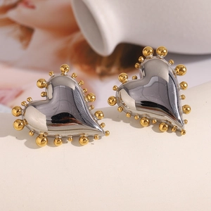 Two-tone heart stud earrings in silver and 18K gold bead finish on ceramic plate