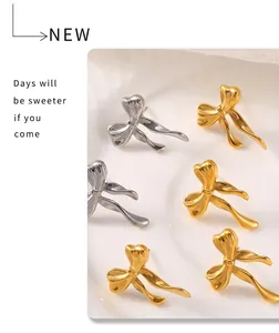 Detailed view of bow-shaped stud earrings in gold and silver finish with metallic texture