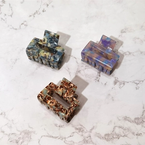 Detailed view of three rectangular acetate claw clips featuring unique marble patterns