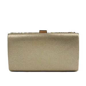 Detailed close-up of golden evening clutch bag featuring a sleek metallic woven texture