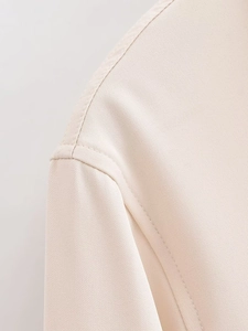 Detailaufnahme des Twill-Gewebes und der feinen Nähte am beigen Damenhemd