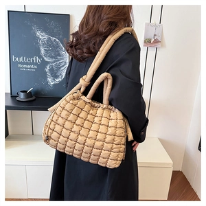 Close-up of quilted puffy shoulder bag in dark khaki with square stitching detail